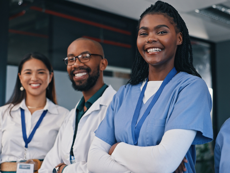 Doctors,,Group,And,Happy,With,Arms,Crossed,In,Hospital,With Friendly young nurse in white coat holding clipboard laughing with elderly female patient during homecare visit consultation